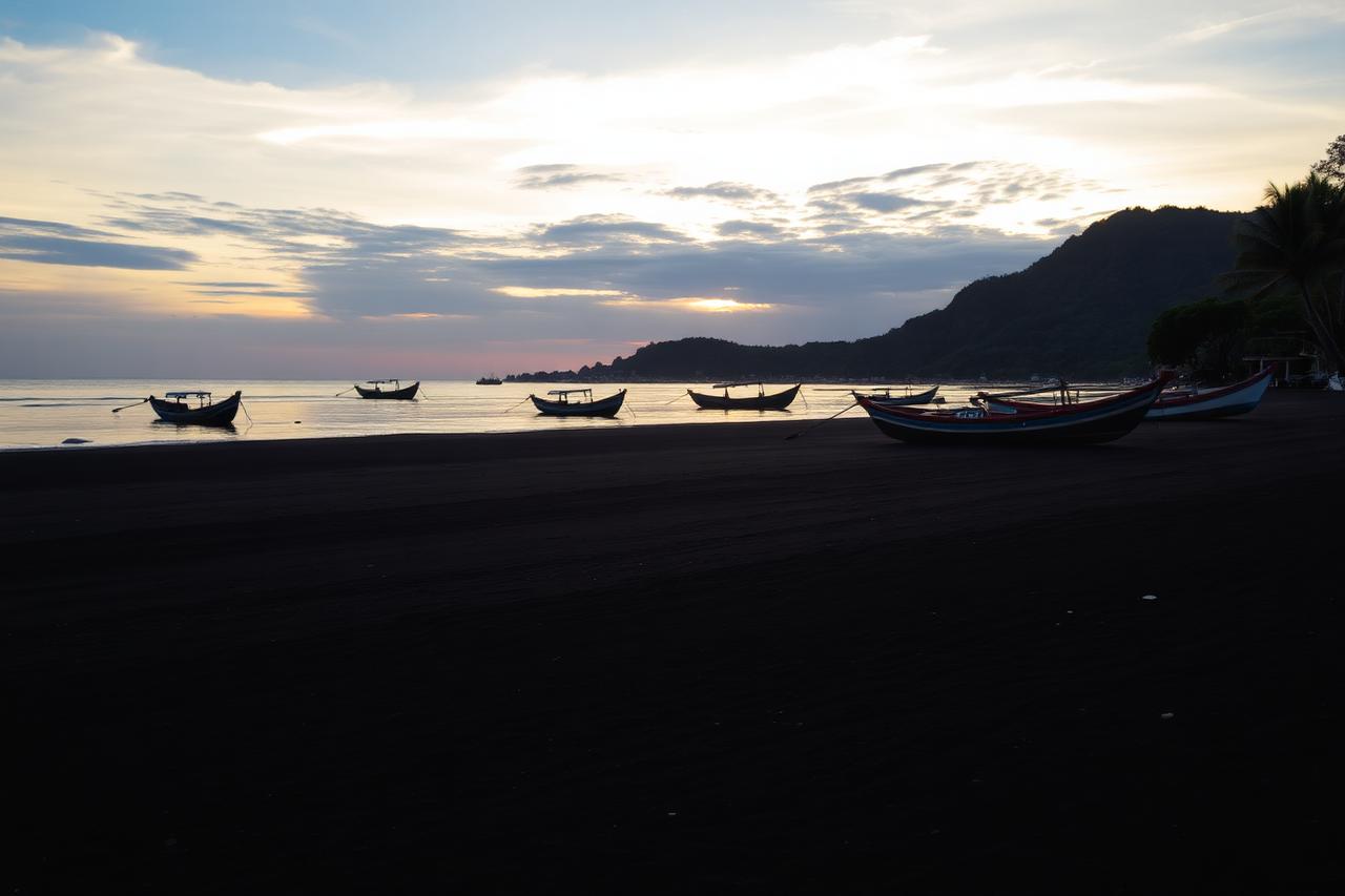 Traditional fishing boats on Pemuteran black sand beach at sunset